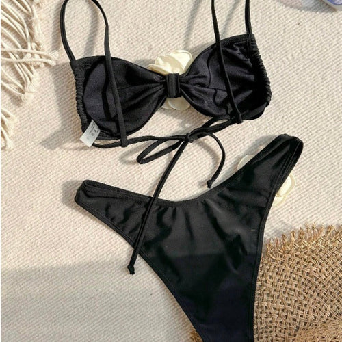 Flora Black Rose Two Piece Bikini with 3D ivory floral accents from 7th of April boutique with a bow detail on a textured surface | 7th of April