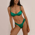 Woman wearing a Laguna Minimalist Two Piece Bikini Set in a high-cut silhouette from 7th of April boutique against a beige background