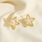 Waterproof Gold Perla Estrella Star Earrings in 18K gold plated stainless steel on a beige fabric background