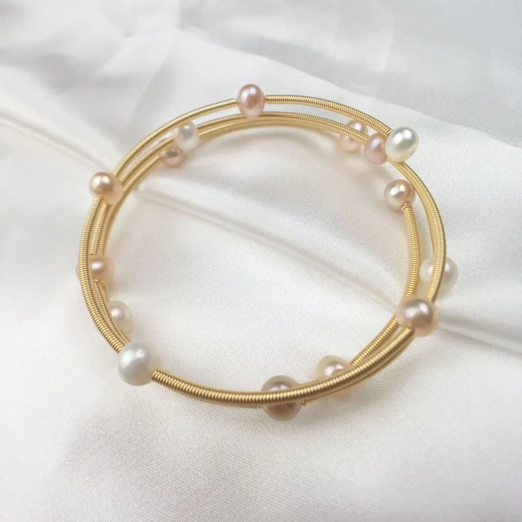 Waterproof Gold Perla Shell Charm Bracelet in 18K gold plated stainless steel on white fabric background