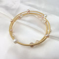 Waterproof Gold Perla Shell Charm Bracelet in 18K gold plated stainless steel on white fabric background