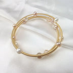 Waterproof Gold Perla Shell Charm Bracelet in 18K gold plated stainless steel on white fabric background