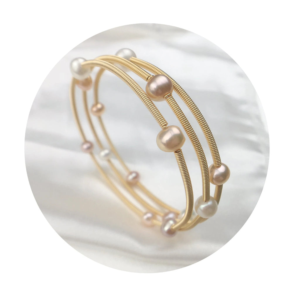 Waterproof Gold Perla Shell Charm Bracelet in 18K gold plated stainless steel on a white shell background
