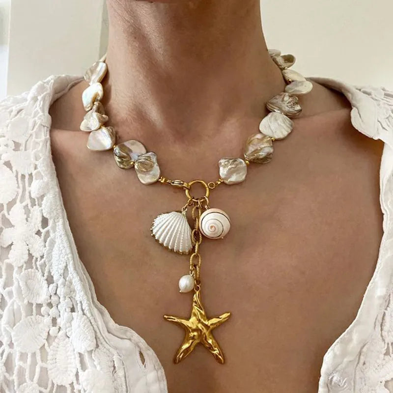 Waterproof Gold Starfish Charm Pendant Necklace in 18K gold plated stainless steel on a person wearing a white lace top | 7th of April