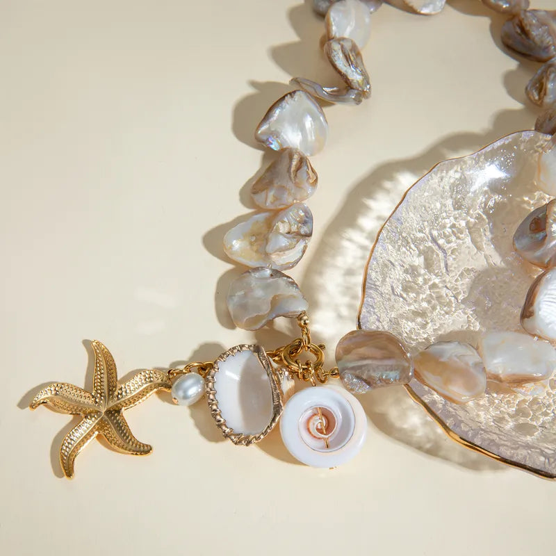 Waterproof Gold Starfish Charm Pendant Necklace in 18K gold plated stainless steel on a light background |7th of April