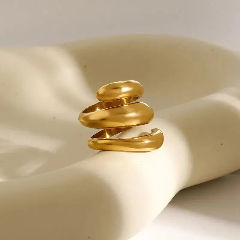 Waterproof Gold Tide Wave Stackable Ring in 18K gold plated stainless steel on a beige fabric background